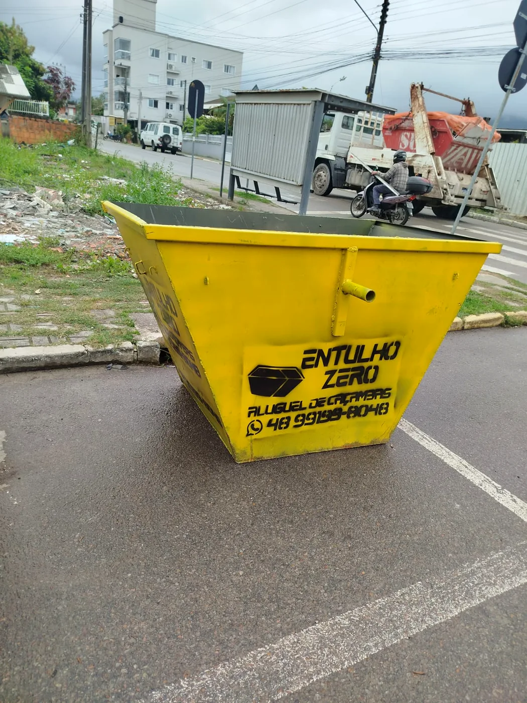 Caçamba amarela da Entulho Zero posicionada em uma via