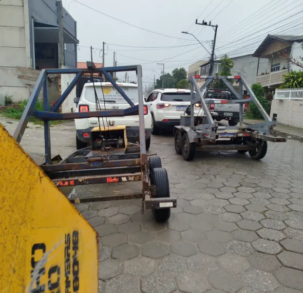 Carretinha metálica azul utilizada no transporte de mini caçambas